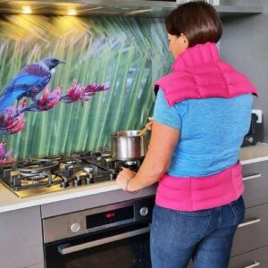 Lady standing at stove cooking a wearing wearable wheat bags